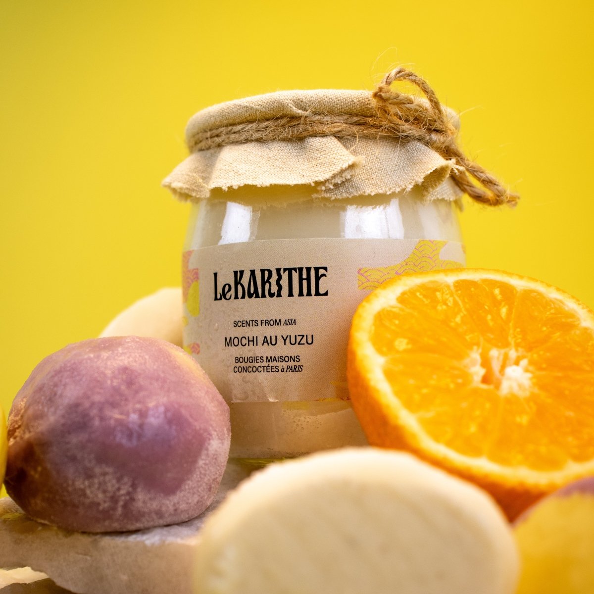 Bougie parfumée aux senteurs du mochi au yuzu (gâteau de riz japonais avec une crème citronnée du Yuzu), aux ingrédients sains et simples, présentée sur fond jaune