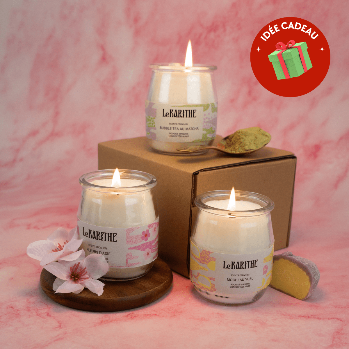 Bougie parfumée aux senteurs de fleurs d'Asie (fleur de cerisier Sakura), aux ingrédients sains et simples, présentées sur fond rose.